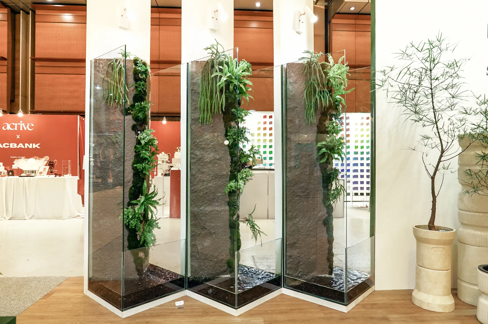 유리 큐브 안에 석재 패널과 이끼, 양치식물로 꾸민 팔루다리움