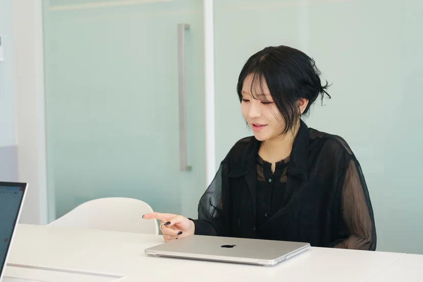 앳홈 팀원이 회의실에서 맥북을 앞에 두고 인터뷰에 응하는 모습