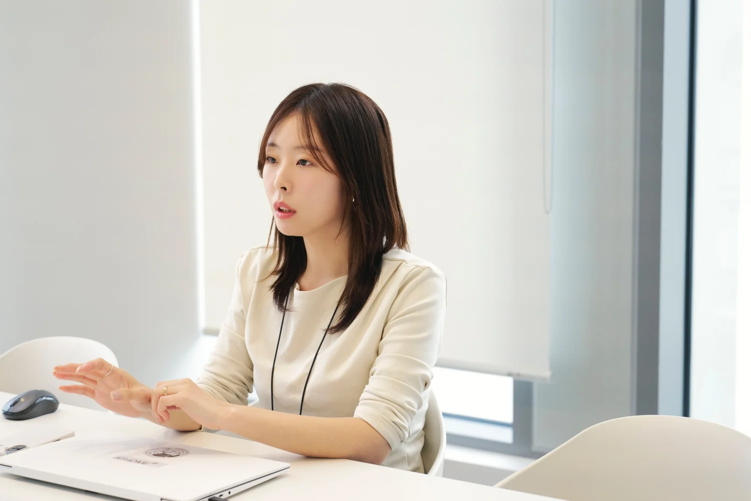 앳홈 상품기획 팀원이 회의실에서 손을 펼치며 이야기하는 모습