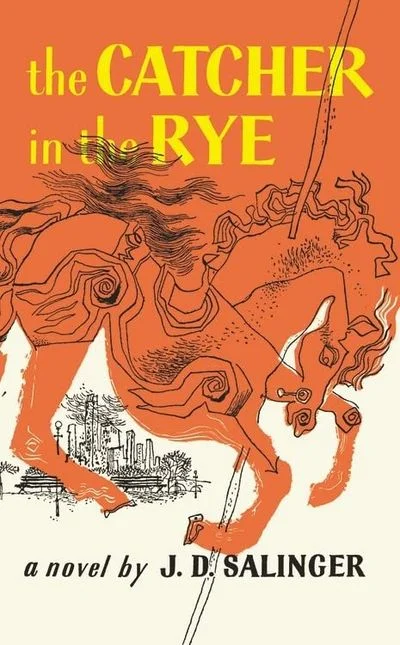 Book cover of The Catcher in the Rye by J.D. Salinger featuring a red carousel horse illustration above a city skyline