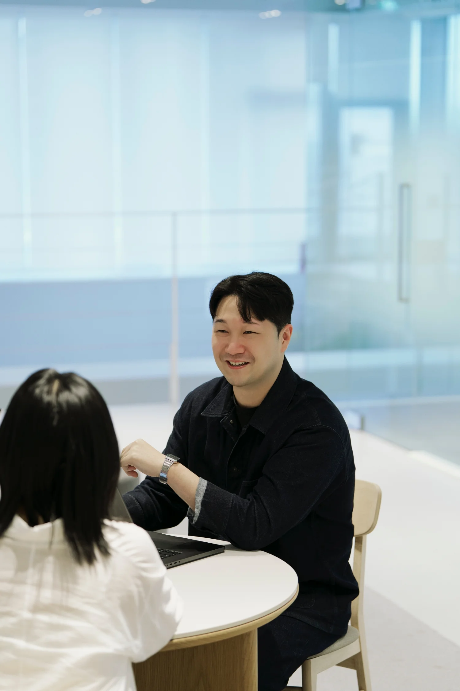 앳홈 팀원이 밝은 라운지에서 인터뷰어와 웃으며 대화하는 모습