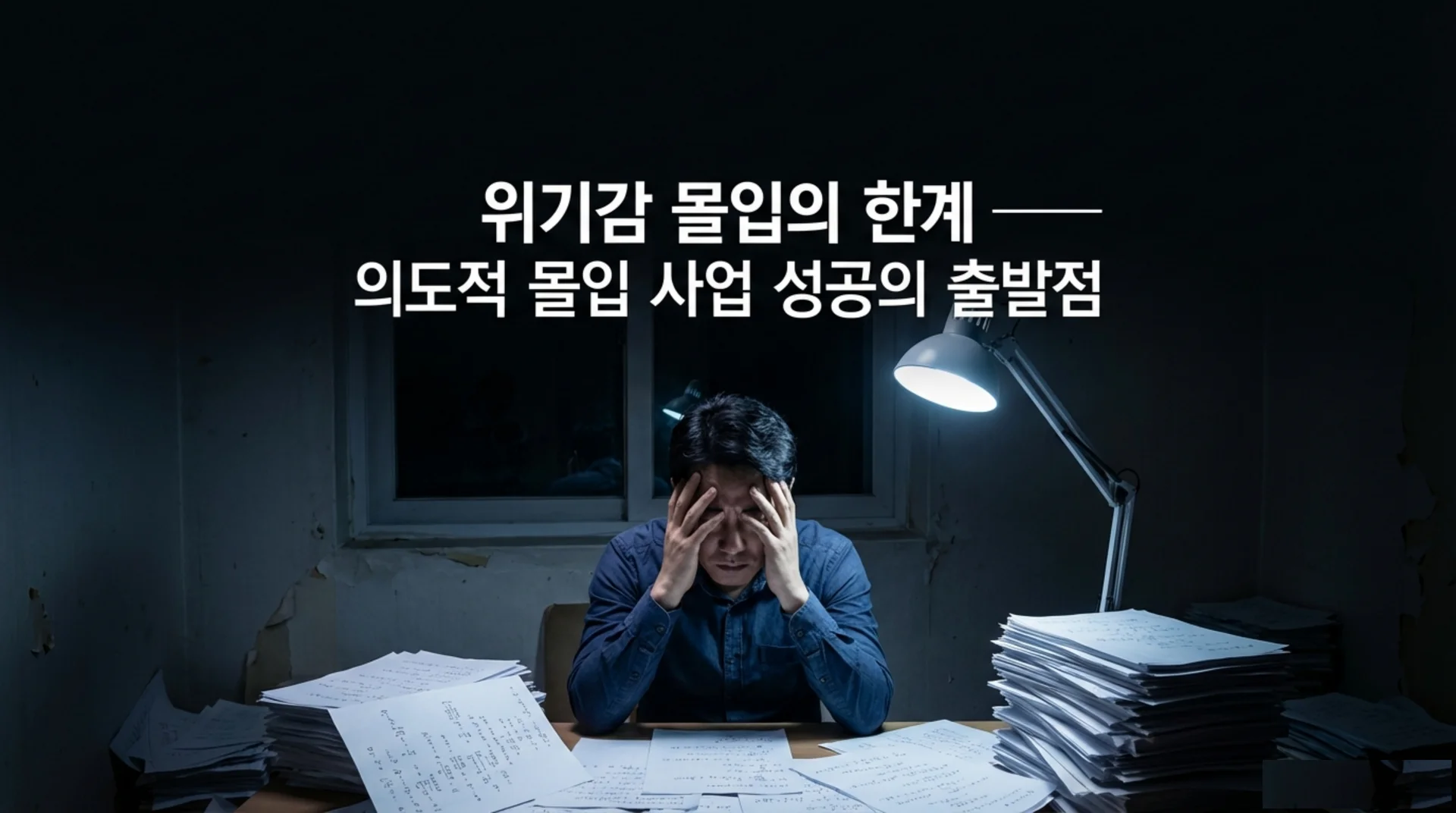 어두운 방에서 책상 위 산더미 같은 서류에 둘러싸여 두 손으로 머리를 감싸 쥔 남성