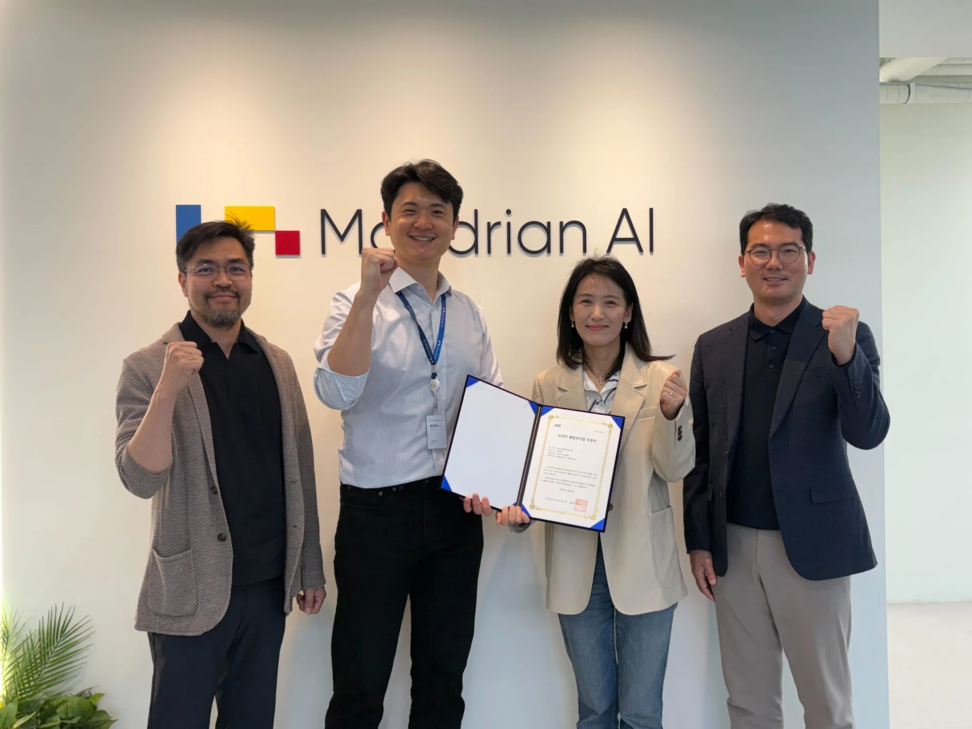 몬드리안에이아이(Mondrian AI) 로고 앞에서 각 기관의 관계자들 4명이 사진을 촬영했다.