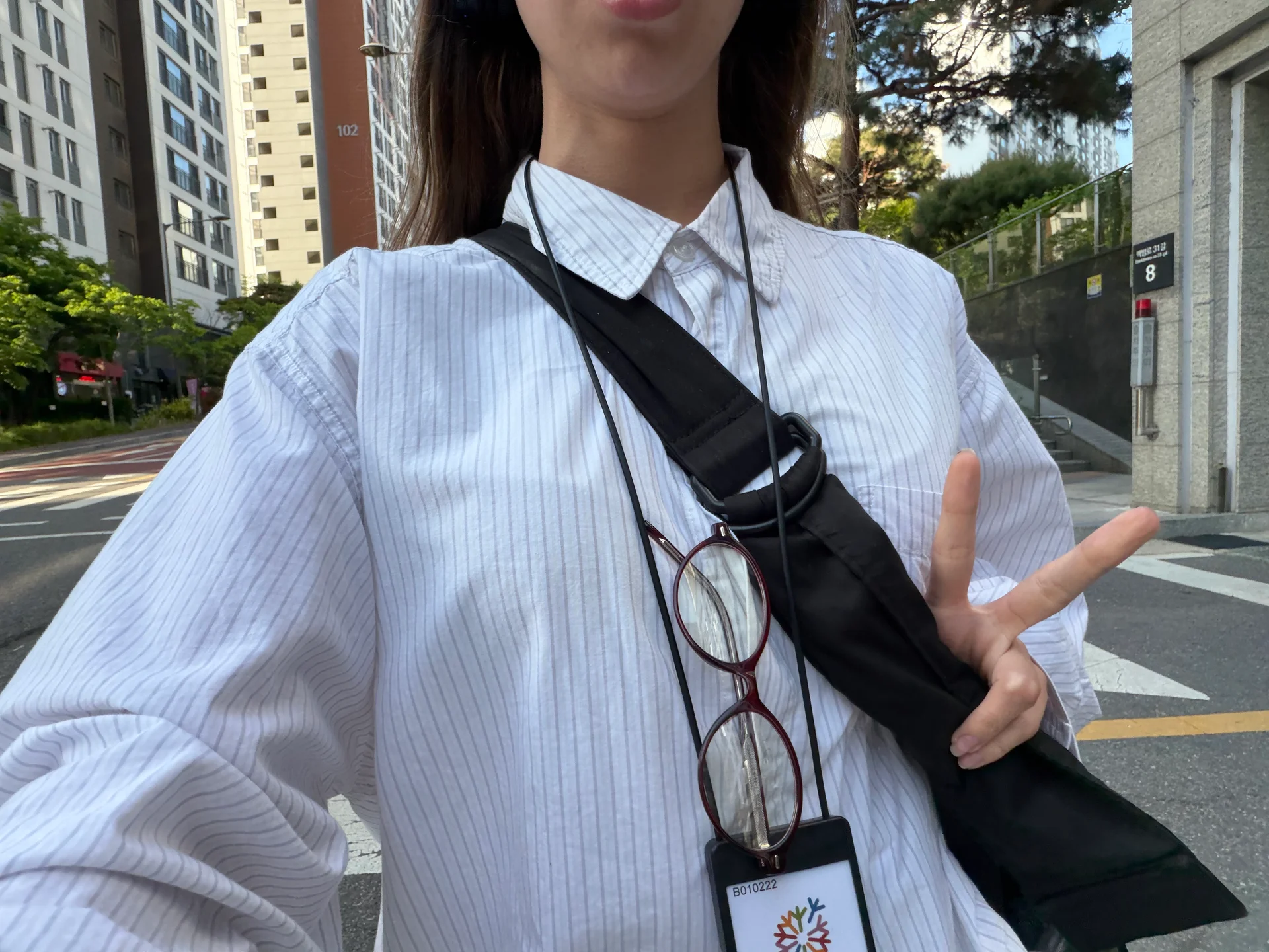 A selfie of a young woman making the peace sign with her fingers.
