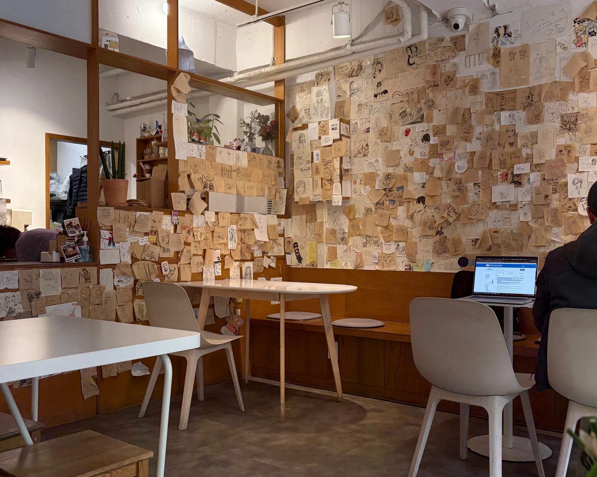 Cozy café with walls covered in small drawings and notes.