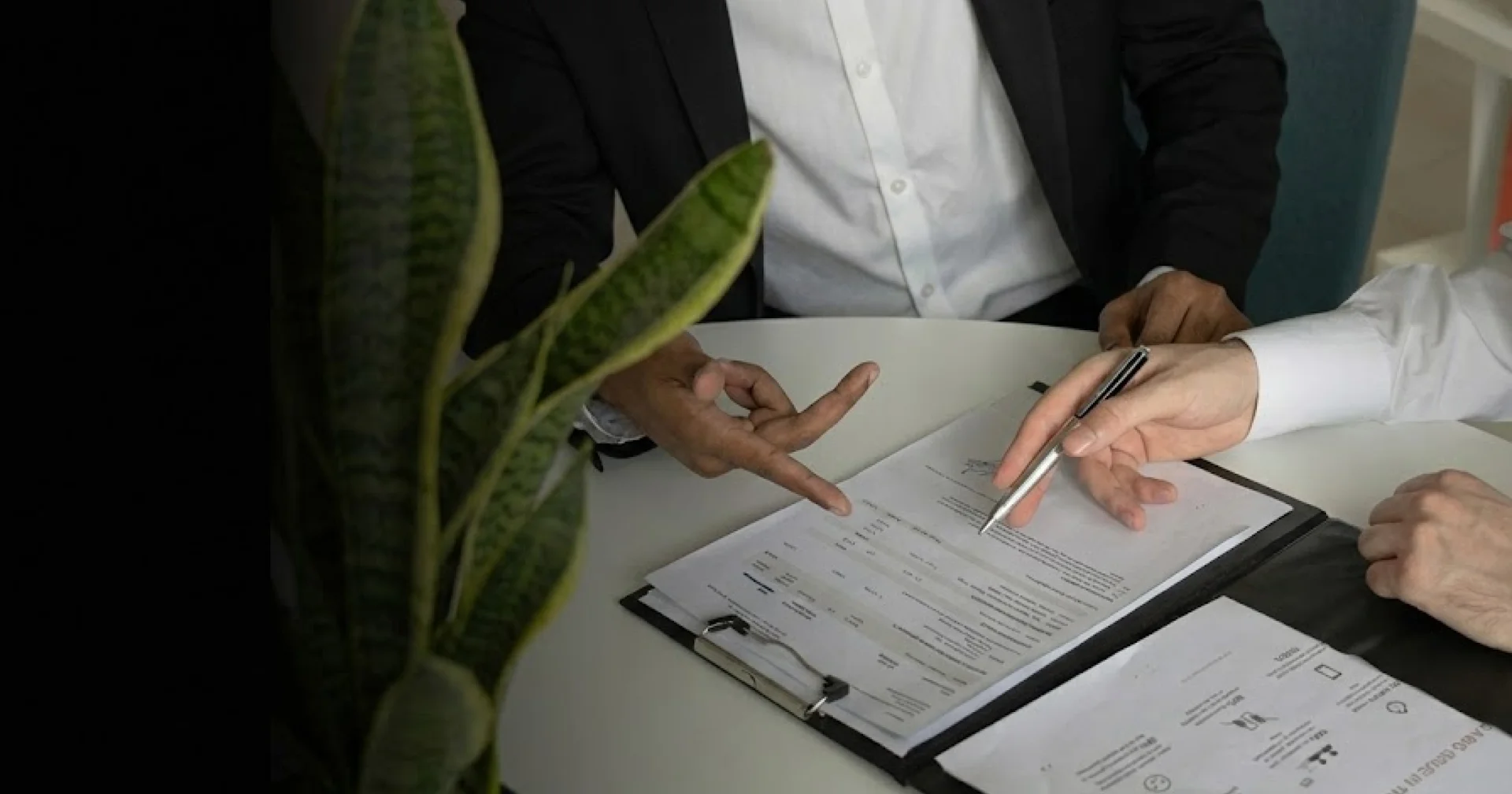 Hands pointing at professional real estate contract documents