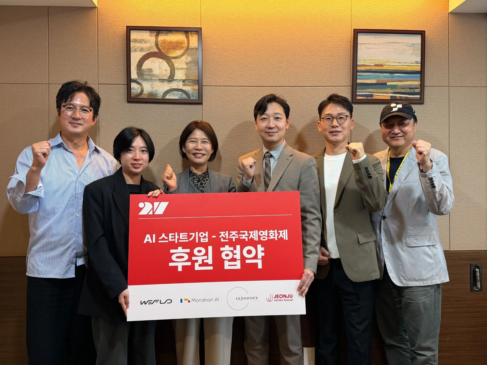 배우 정준호, 전주국제영화제조직위원회 공동집행위원장, 트웰브져니 연동은 대표, 전주시 문화체육관광국 노은영 국장, 몬드리안에이아이 홍대의 대표, 위플로 김의정 대표, 민성욱 전주국제영화제조직위원회 공동집행위원장이 AI 기술 협력 MOU를 체결하는 모습이다.