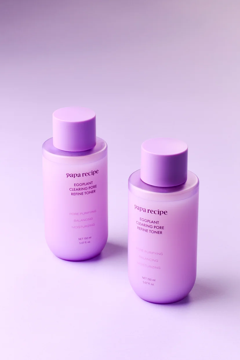 Two Papa Recipe Eggplant Clearing Pore Refine Toner 150ml bottles standing side by side against a lavender gradient background, labeled with pore purifying, balancing, and moisturizing