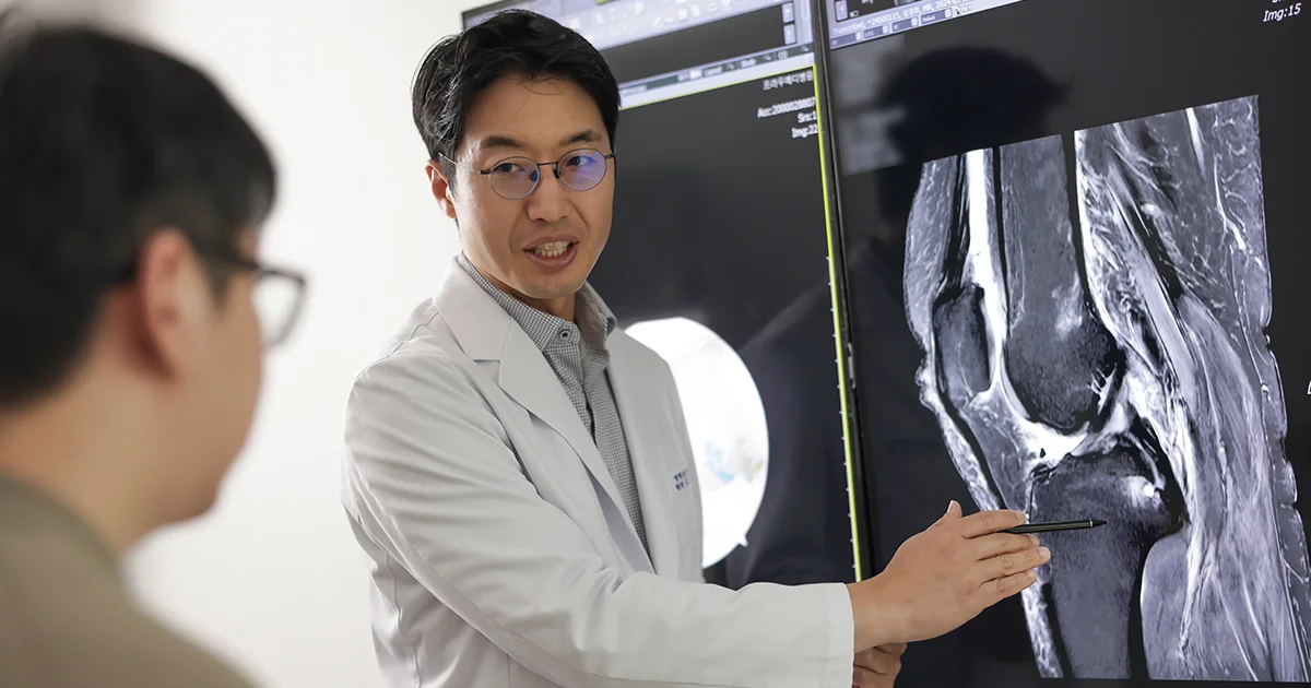 더프라우병원의 정형외과 전문의 김동환 원장이 모니터 화면의 MRI 영상을 보면서 환자의 상태를 설명하는 모습