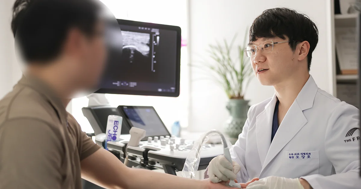 더프라우병원의 수부외과 오상호 원장이 초음파 영상 장비를 이용하여 수부질환을 호소하는 환자의 손을 검사하는 장면