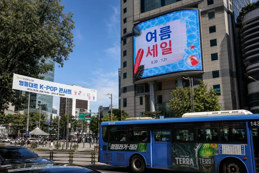 디지털 사이니지와 버스 래핑, 현수막 등 여러 옥외광고 종류가 함께 보이는 한국 도심 거리 실사 사진