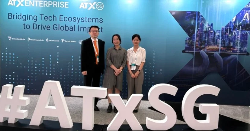 'ATxSG 2025'에 참가한 크라우드웍스 직원 3명이 단체 사진을 찍고 있는 모습