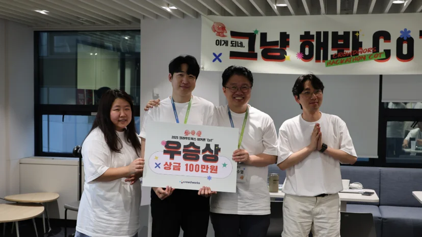 CTO를 포함한 4명의 직원이 우승상 팻말을 들고 활짝 웃고 있는 이미지