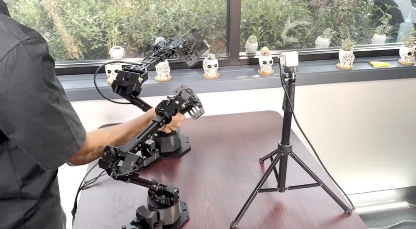 Trossen Robotics의 알로하 로봇. 사람의 손으로 원격 조종되는 로봇 팔의 움직임을 시연하고 있는 장면