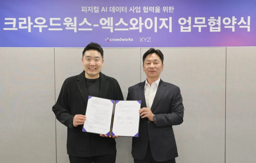 크라우드웍스와 엑스와이지 관계자가 로봇 학습 데이터 협력을 위한 업무협약 체결 후 협약서를 들고 기념 촬영하는 모습