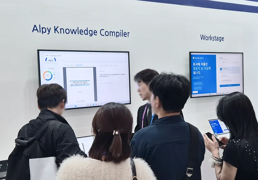 AI EXPO 2026 크라우드웍스 부스에서 Alpy Knowledge Compiler와 Workstage 솔루션 데모를 관람객들에게 소개하는 모습