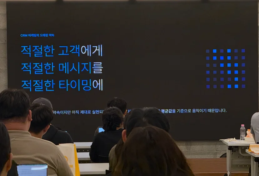 참석자들이 '적절한 고객에게 적절한 메시지를 적절한 타이밍에' CRM 마케팅 슬라이드를 바라보는 세미나 현장