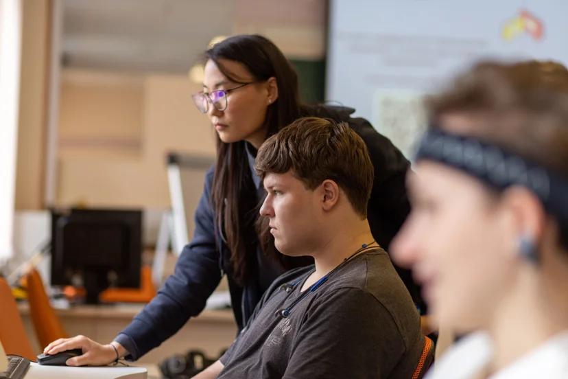 Teacher helps a student with online classroom activities.