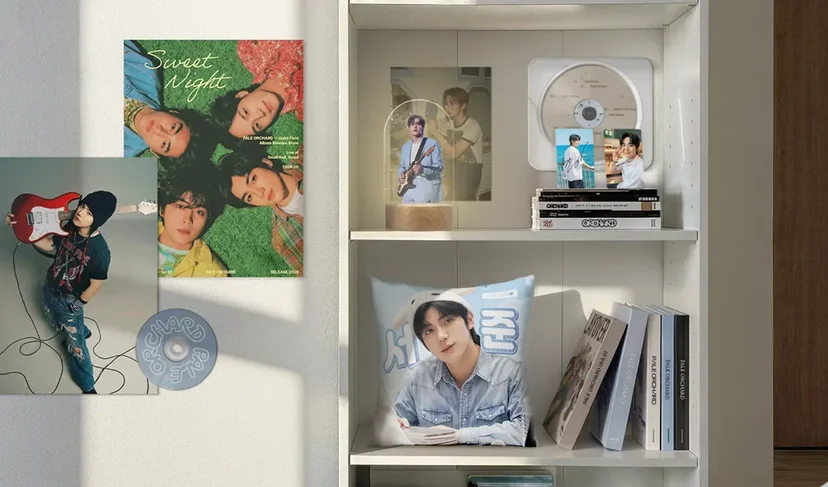 마플 최애존 굿즈 – 남성 아이돌 사진을 인쇄한 포스터와 포토카드, CD, 아크릴 무드등, 쿠션을 흰색 벽과 선반에 함께 꾸민 이미지