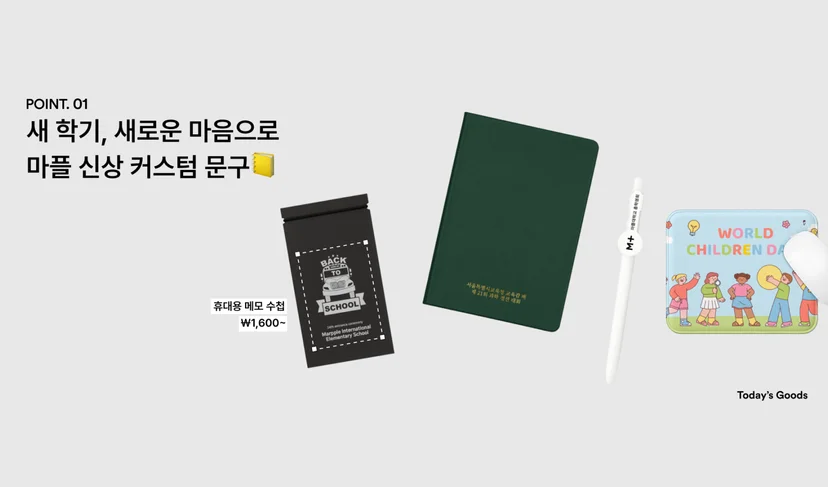 마플 신학기 문구 굿즈 – 학교 로고를 인쇄한 휴대용 메모 수첩과 초록색 다이어리, 흰색 볼펜, 어린이 일러스트 마우스패드를 회색 배경에 나란히 배치한 이미지