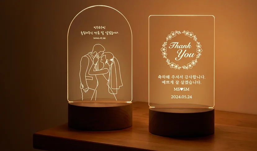마플 아크릴 무드등 – 신랑 신부 선화 일러스트와 결혼 날짜를 새긴 아치형 무드등, 꽃 테두리와 감사 문구를 넣은 직사각형 무드등을 따뜻한 조명 아래 나란히 켠 이미지