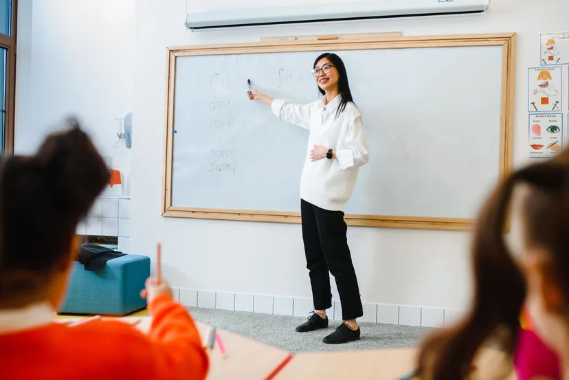 Teacher conducts a lesson with a traditional whiteboard.