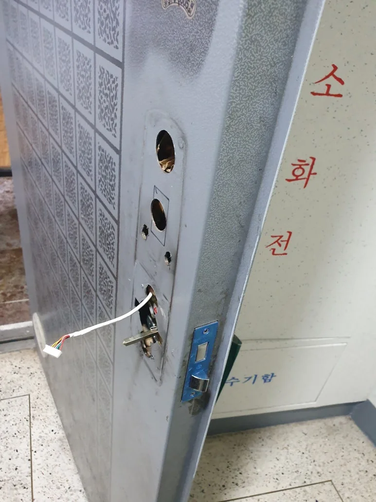 테이프로 고정한 흔적과 손상이 남아 있는 기존 번호키 내부