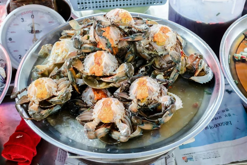 수산시장 대야에 푸짐하게 담긴 노란 알이 차오른 간장게장 게 껍데기들