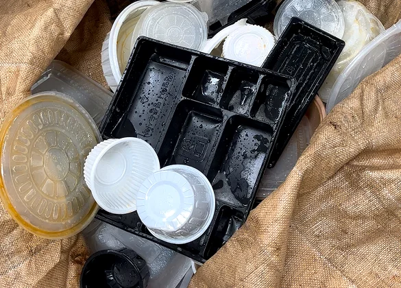 마대 자루 안에 깨끗이 세척되어 수거 분류된 검은색 배달용기 및 플라스틱 뚜껑들