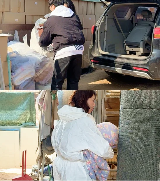 차량 트렁크에서 유기견 보호소로 전달할 헌 이불 짐을 싣고 들고 옮기는 모습