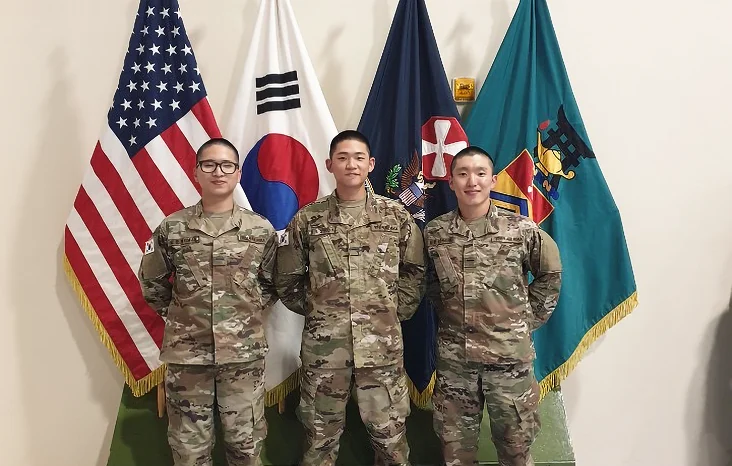 태극기와 미군 기발 앞에 카투사 군복을 입고 기념 사진을 찍은 3명의 오늘수거 창립자들