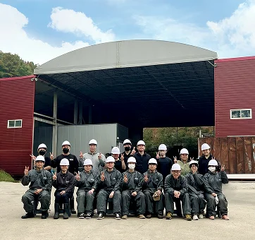 오늘수거 직영 선별장 건물 앞에서 안전모를 쓰고 손가락 브이를 하는 임직원 단체 단체사진