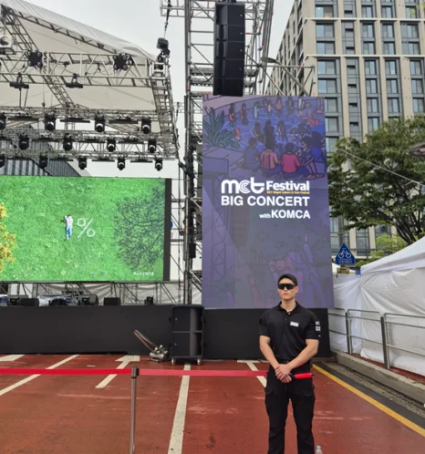 야외 행사장 주변을 살피는 사람