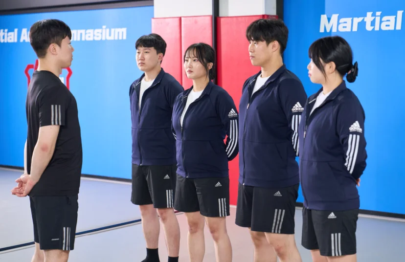체육관에서 설명을 듣는 사람들
