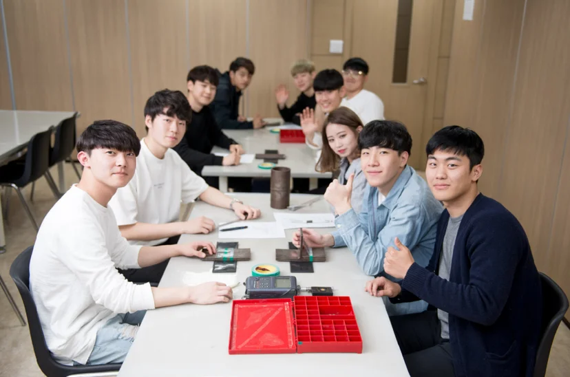 테이블에서 자료를 함께 보는 학생들