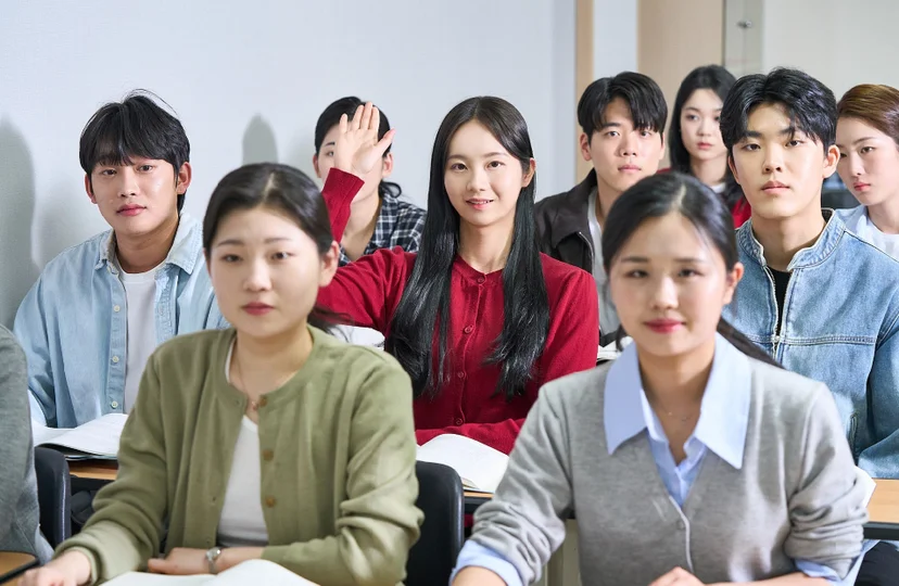 교실에 여러 사람이 앉아 한 사람이 손을 들고 있는 모습