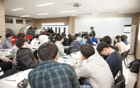 강의실에서 설명을 듣는 학생들