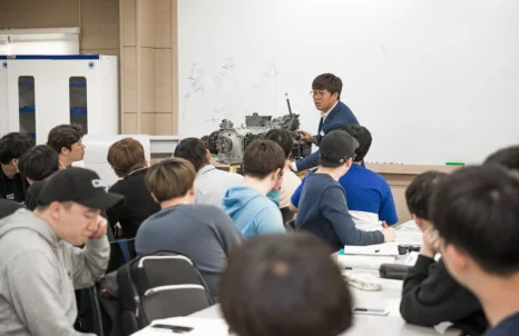 강의실에서 설명을 듣는 학생들