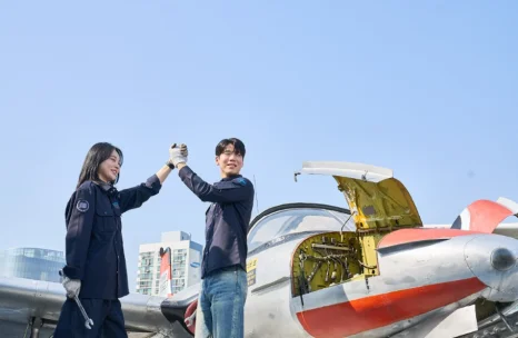 실습용 항공기 앞에서 하이파이브하는 실습생들