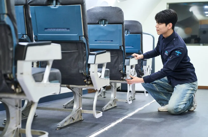 항공기 객실 좌석 아래 구조를 살펴보는 실습생