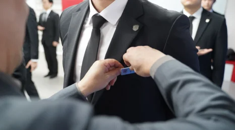정장을 입은 사람의 옷차림을 정돈하는 모습