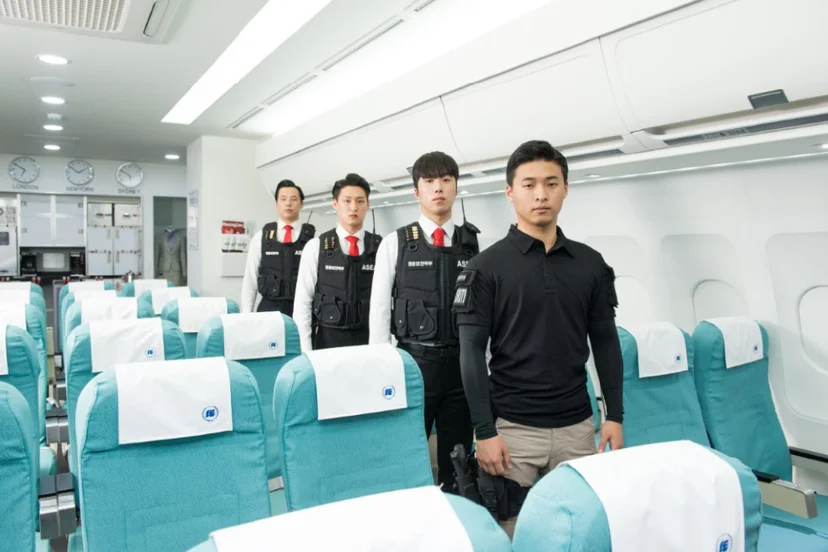 항공기 객실 모형 안에 서 있는 사람들