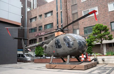 학교 건물 앞에 전시된 헬리콥터