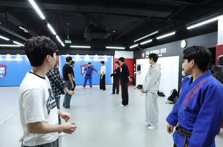 도복과 운동복 차림 학생들이 넓은 실내에서 서 있는 모습