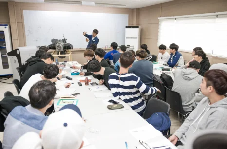 강의실에서 설명을 듣는 학생들