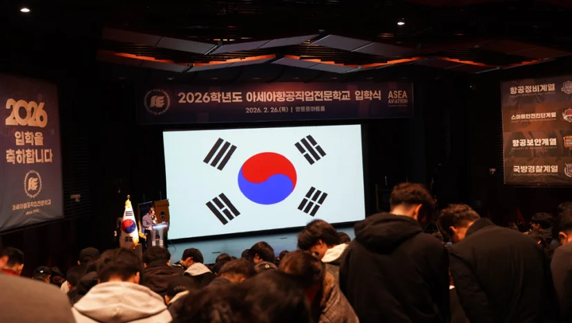 무대에서 국기를 바라보는 참석자들