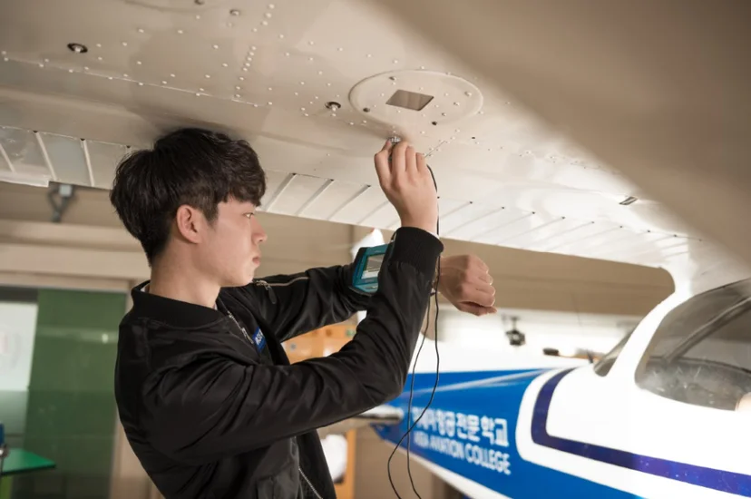 항공기 객실 상단 수납함을 점검하는 모습