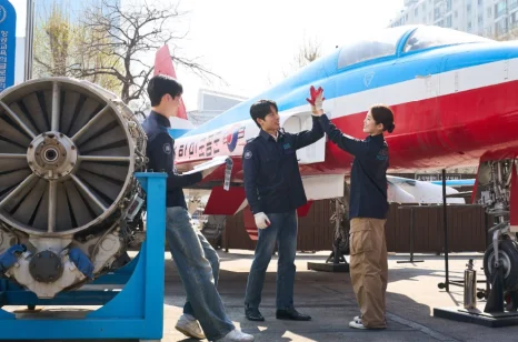 훈련용 항공기 앞에서 이야기하는 학생들