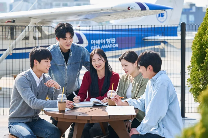 훈련용 항공기 앞에서 이야기하는 학생들