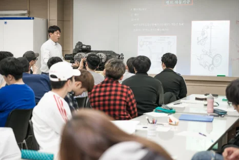 교실에서 화면 자료를 보며 설명을 듣는 모습